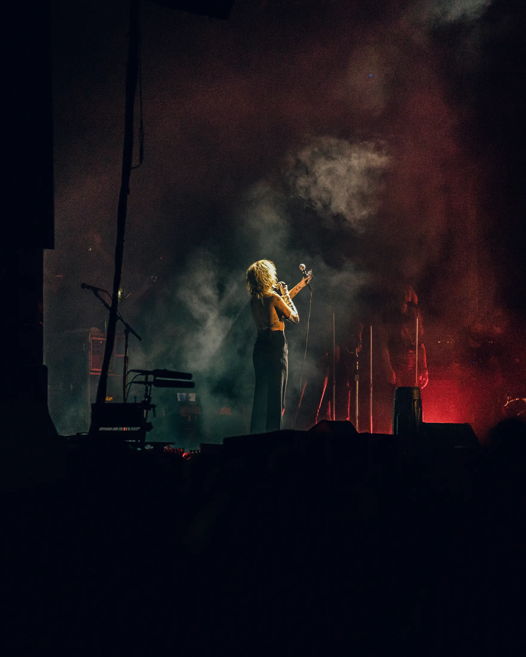 singer on a smoky stage under red light