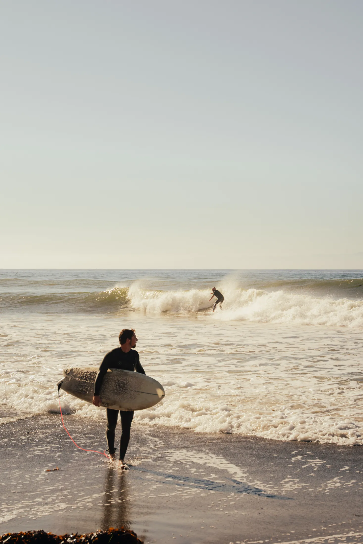 surfer walking out of the ocean
