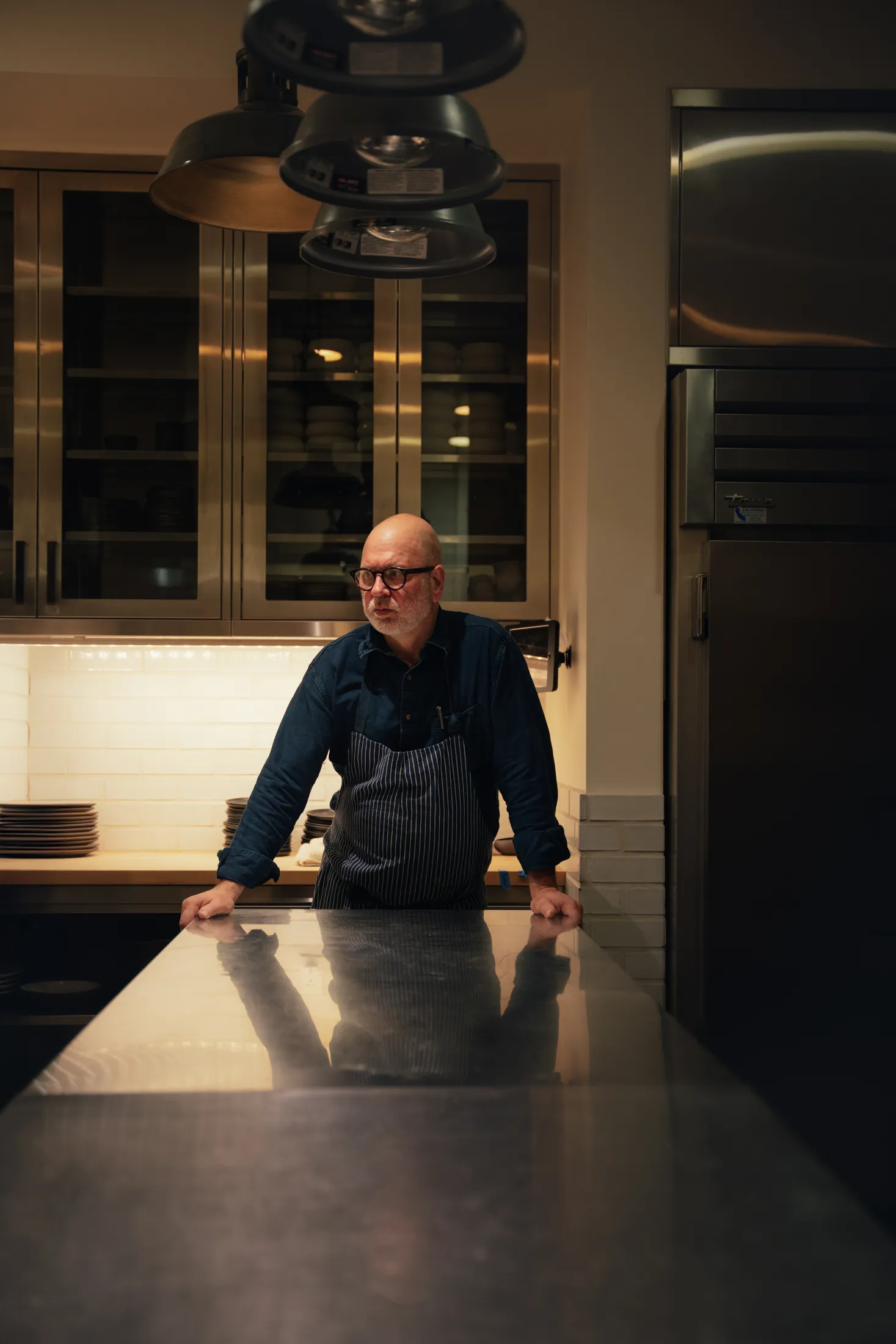 chef at a steel kitchen pass