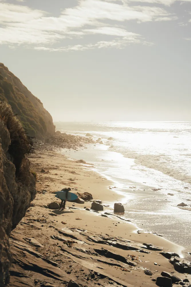 sunlit coastline with waves on a rocky beach