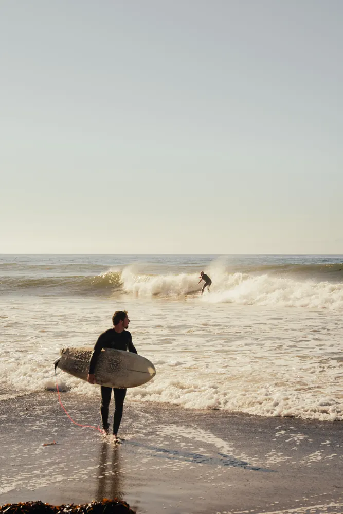 surfer walking out of the ocean