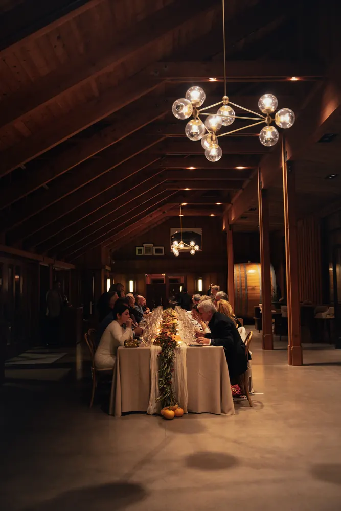 dinner party in a barn under a chandelier